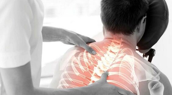 Doctor examining back pain below left shoulder blade